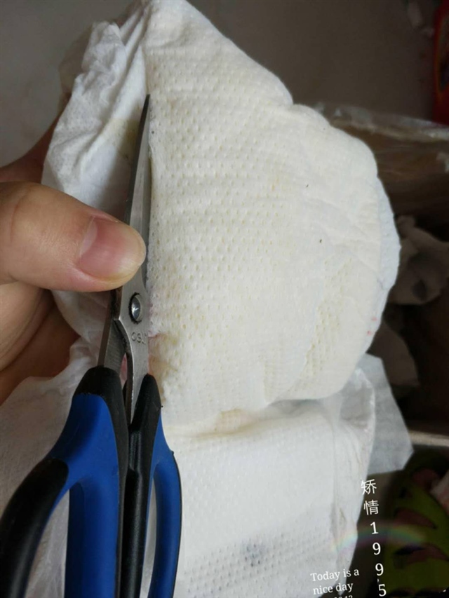 2.沿着边，挑起最上面的那层棉纸剪一圈，剪的时候要小心别把防水层剪到了，剪到两头时剪的多些，要用剪子小心挑起，