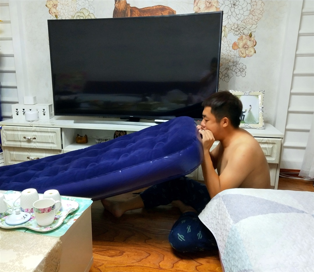 老公在替我把气垫床吹起来。