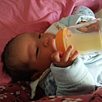 儿子出生第七天，自己捧着奶瓶喝奶，真是个贪吃会吃的猪宝宝