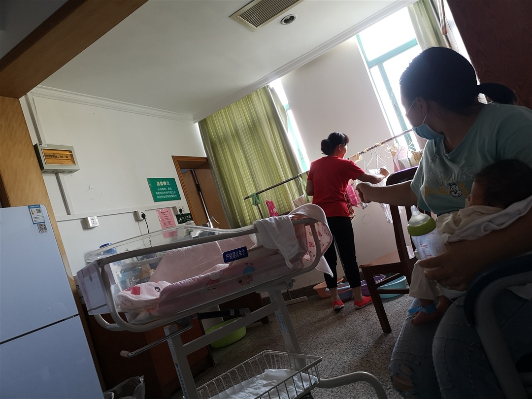 红衣服婆婆，月嫂抱着宝宝。