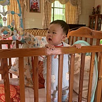 小家伙把他放小床会自己掰着栏杆站起来