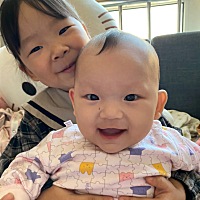 3岁4个月的姐姐抱着5个月的妹妹 开心 妈妈自己带两个宝贝出游 爱笑的女孩